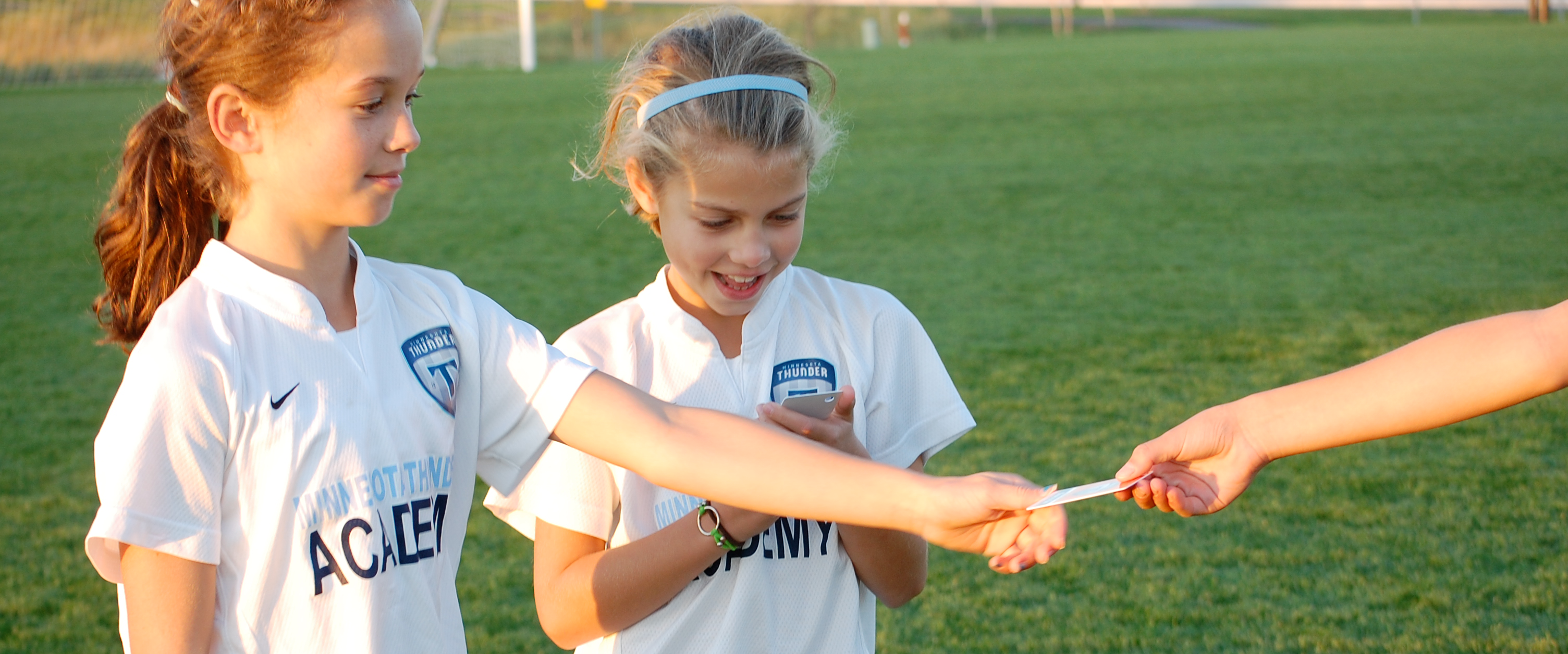 A coach handing a Game Award Skill Tag&reg; to a young soccer player after the game
