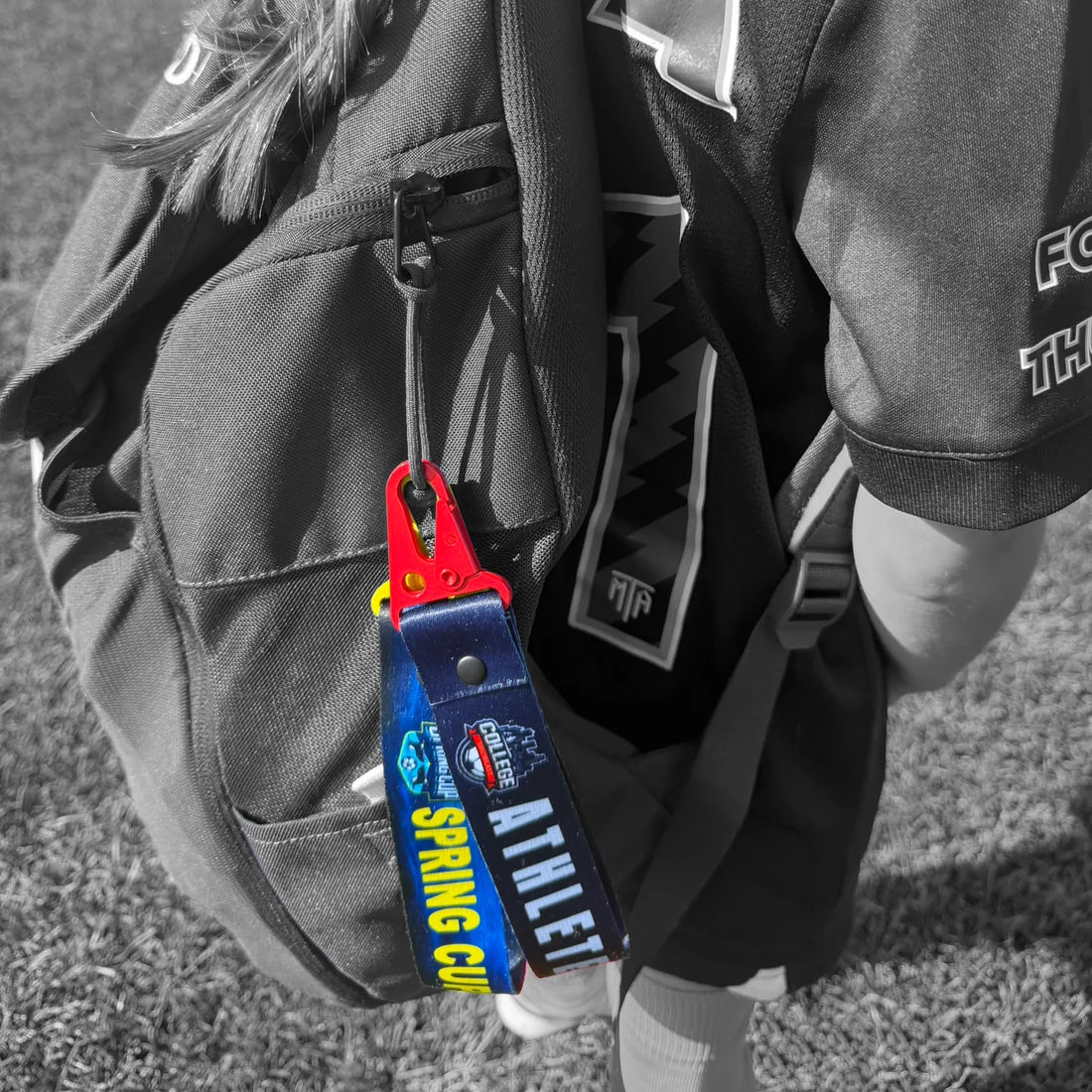 StrapTag clipped to a young athlete's sports backpack